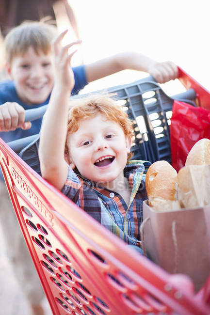 Children playing with shopping cart — Stock Photo