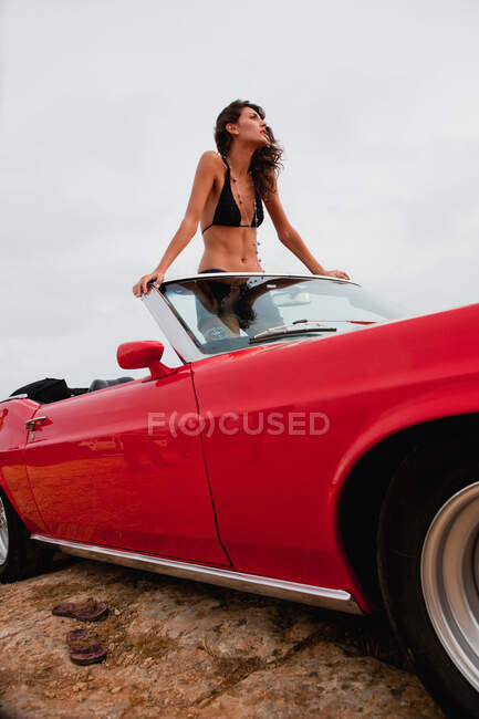 Woman standing in an open-topped car — Stock Photo