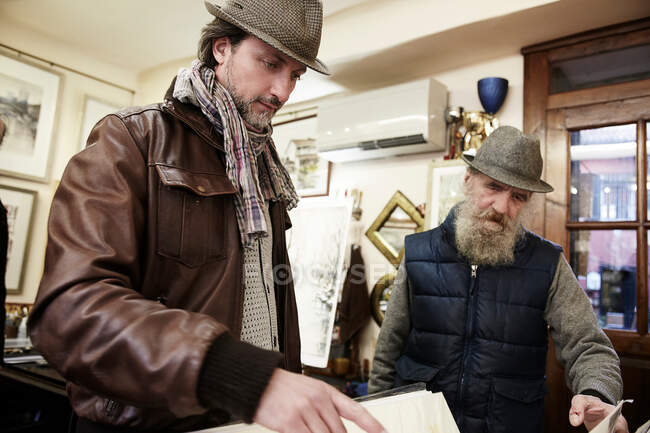 Senior and mid adult man in antique shop — Stock Photo