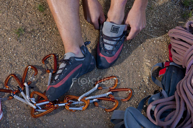 Cropped shot of young male climber putting on trainers — Stock Photo