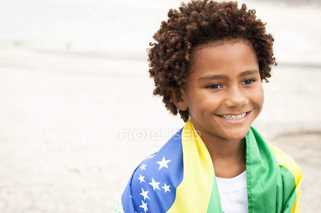 Niño envuelto en bandera brasileña en la playa de Ipanema, Río de Janeiro,  Brasil — Pelo castaño, Viajes - Stock Photo | #169038080