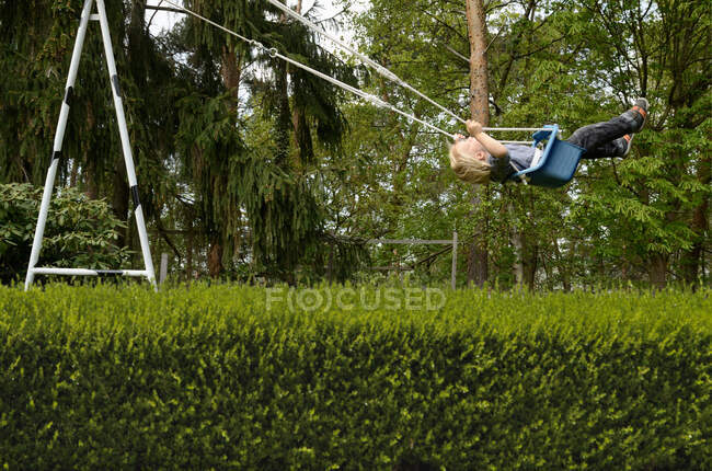 Boy on playground swing — Stock Photo