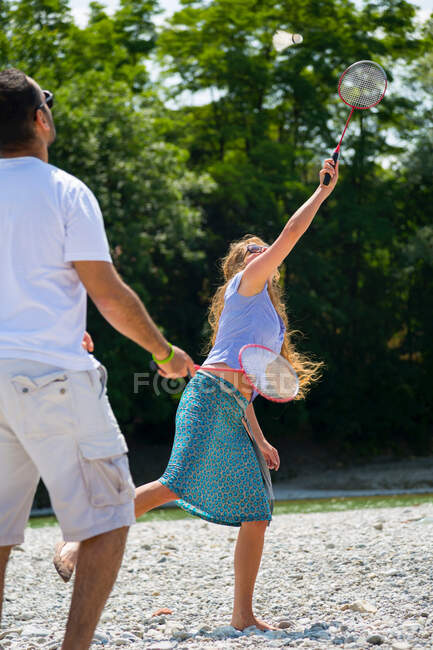 Mid adult couple playing badminton — Stock Photo