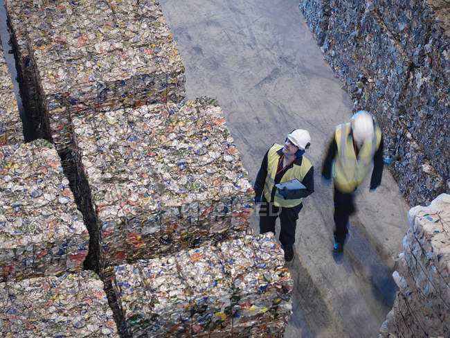 Trabajadores con fardos de latas - foto de stock