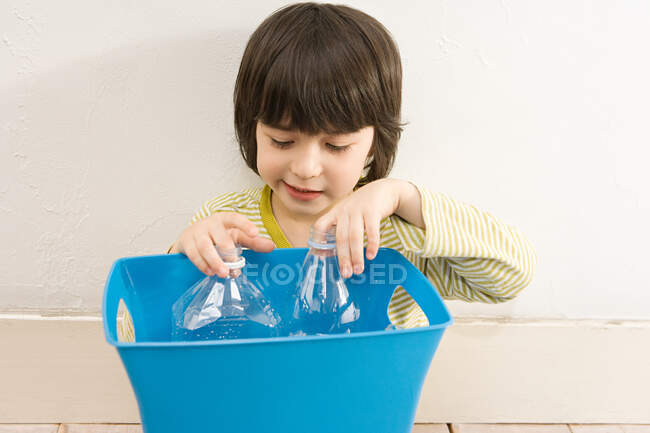 Un garçon tenant une poubelle de recyclage — Photo de stock
