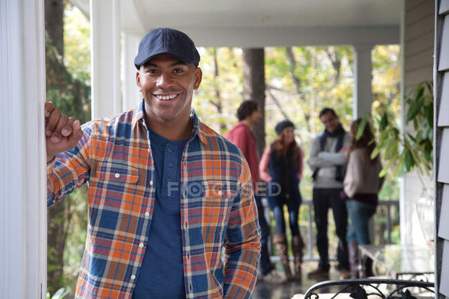 Lächelnder Mann steht auf Veranda — Stockfoto