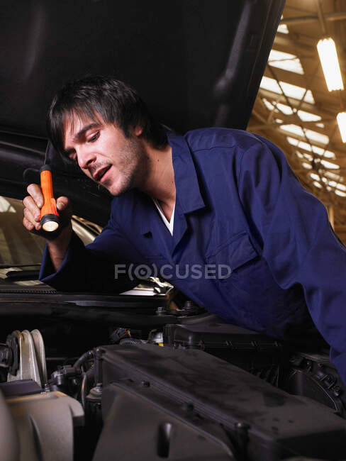Mécanicien travaillant sur un moteur — Photo de stock