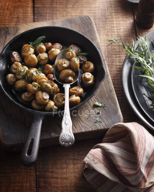 Tarragon button mushrooms in frying pan — Stock Photo