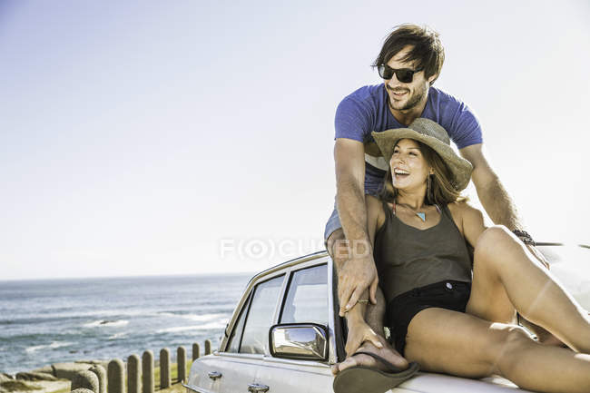Casal adulto médio olhando para fora do topo do carro na estrada da costa, Cidade do Cabo, África do Sul — Fotografia de Stock