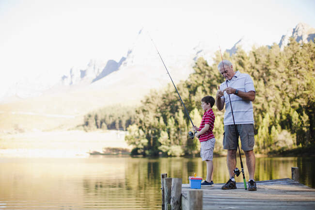 Garçon pêche avec grand-père dans le lac — Photo de stock