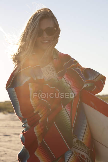 Mujer joven envuelta en manta, Breezy Point, Queens, Nueva York, Estados Unidos - foto de stock