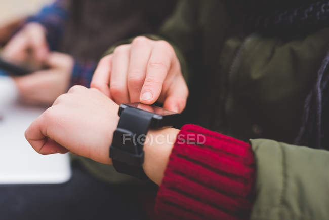Jovem mulher usando smartwatch, ao ar livre — Fotografia de Stock