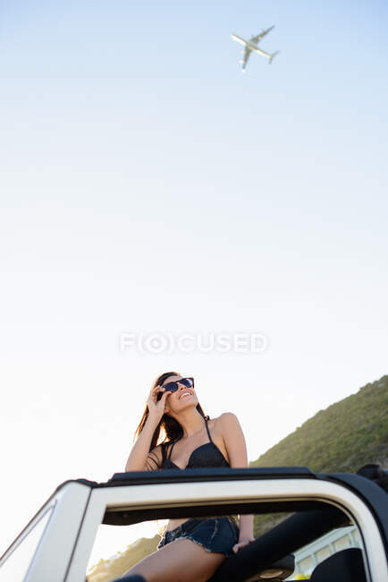 Mulher sentada no telhado de jipe na praia — Fotografia de Stock