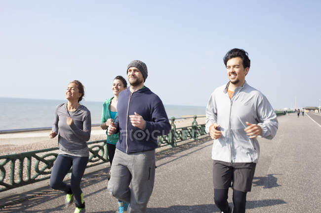 Läufer und Läuferinnen laufen gemeinsam am Strand von Brighton — Stockfoto