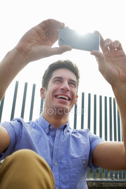 Man using cell phone on city street — Stock Photo