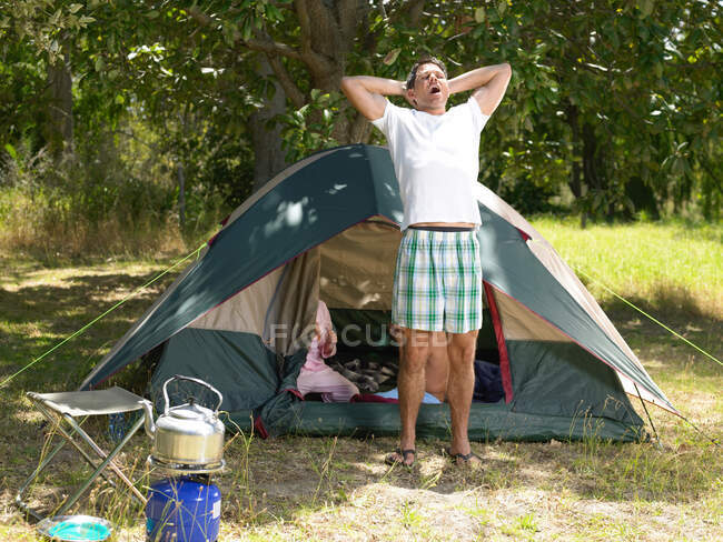 Homme étirant la tente extérieure — Photo de stock