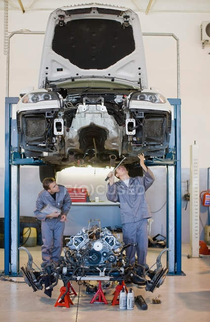 Mechanics working on car in garage — Stock Photo