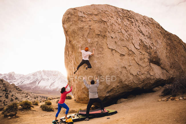 Amigos escalando rocas, Buttermilk Boulders, Bishop, California, EE.UU. - foto de stock