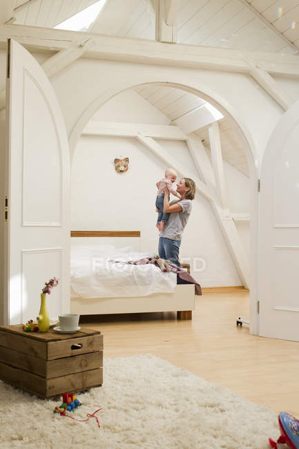 Reife Mutter hält Baby-Tochter im Schlafzimmer — Stockfoto