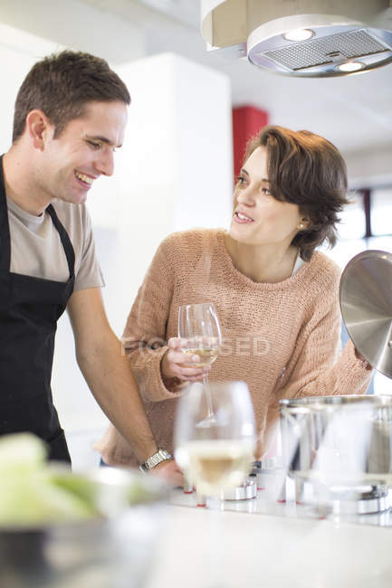 Couple drinking glass of white wine in kitchen — Stock Photo
