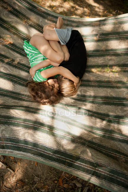 Двое детей лежат на гамаке — стоковое фото