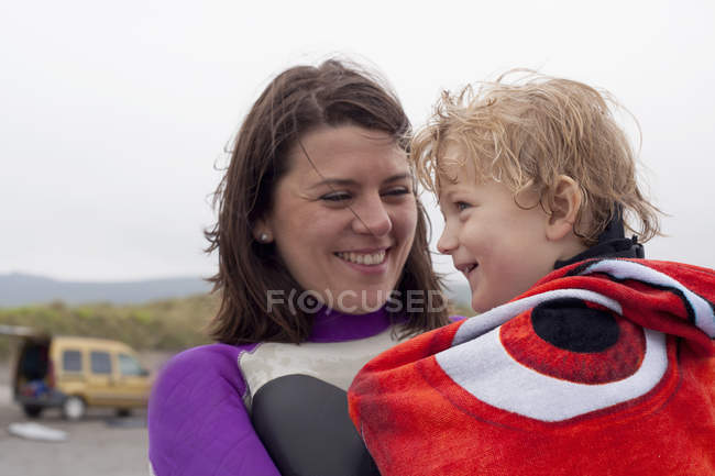 Portrait of mother holding son wrapped in a towel — Stock Photo