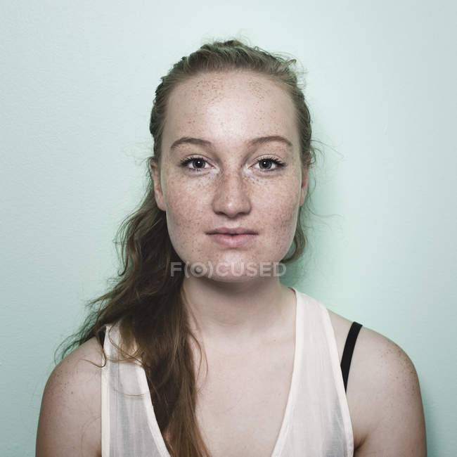 Portrait de jeune femme avec des taches de rousseur regardant la caméra — Photo de stock