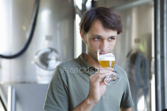 Brasseur masculin dégustation verre de bière — Photo de stock