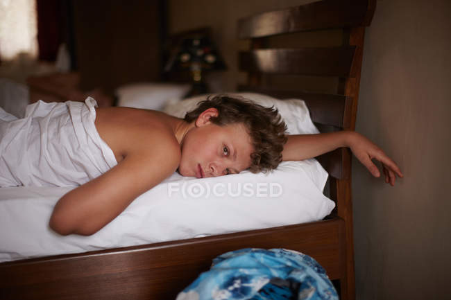 Teenage boy relaxing in bed — Stock Photo