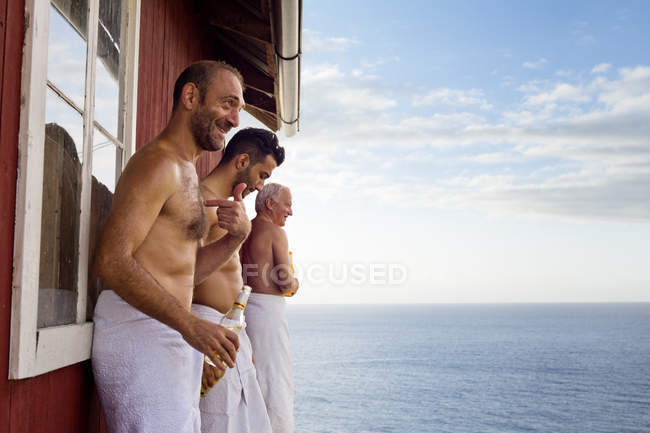 Три друга-мужчины стоят снаружи сауны — стоковое фото
