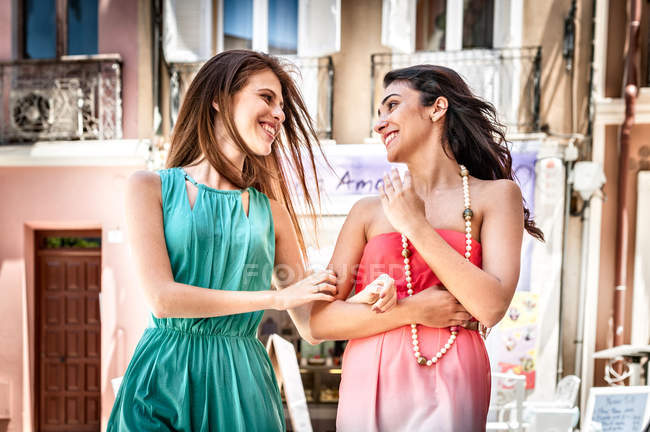 Dos mujeres jóvenes de moda charlando y paseando por la calle, Cagliari, Cerdeña, Italia - foto de stock
