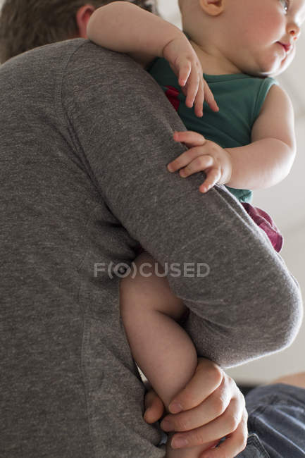 Закрытие отца, выносящего на руках маленькую дочь — стоковое фото