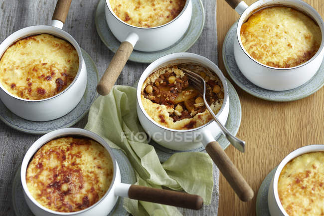 Potato lamb moussaka in individual saucepans — Stock Photo
