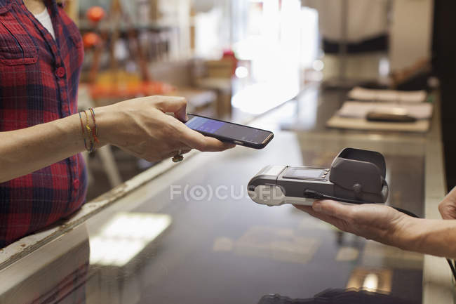 Cropped view of womans hands using smartphone to make contactless payment on smartphone — Stock Photo