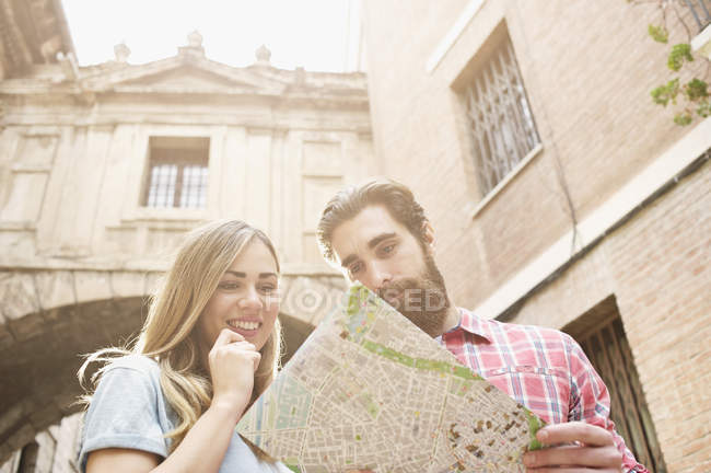 Jovem casal turístico olhando para o mapa fora da Catedral de Valência, Valência, Espanha — Fotografia de Stock