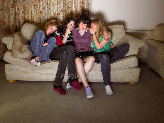 Mulheres, sentadas no sofá, parecendo tristes — Fotografia de Stock