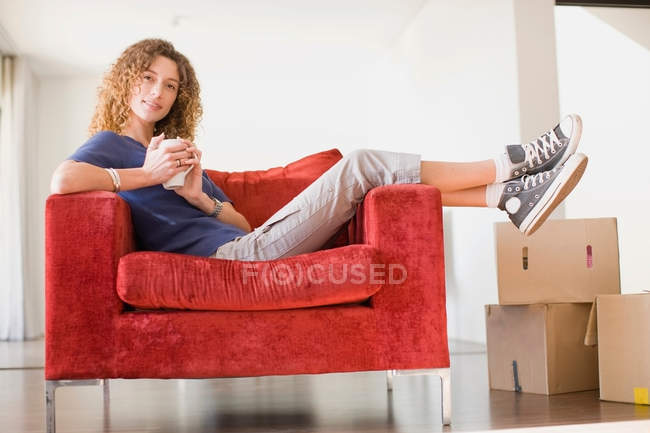 Woman having coffee in armchair — Stock Photo