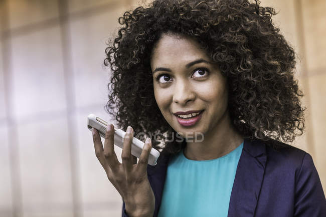 Junge Geschäftsfrau spricht im Büro mit Smartphone — Stockfoto
