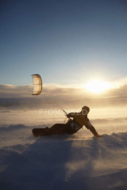 Man windsurfing on snowboard at sunny day — Stock Photo