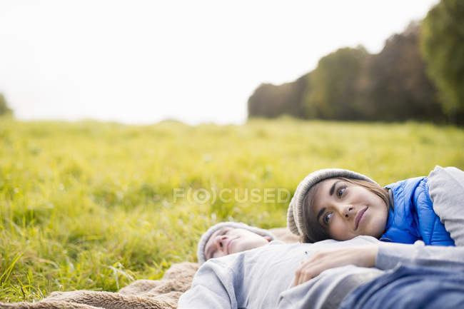 Молода жінка спить голову на грудях чоловіка в парку — стокове фото
