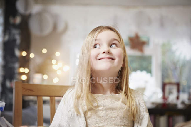 Retrato de menina na cozinha puxando um rosto — Fotografia de Stock