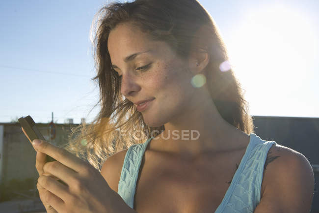 Портрет молодой женщины с помощью мобильного телефона — стоковое фото