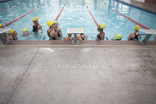 Gran grupo de colegialas tomando un descanso en la piscina - foto de stock