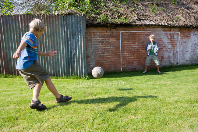 Child footballer shooting at goal — Stock Photo