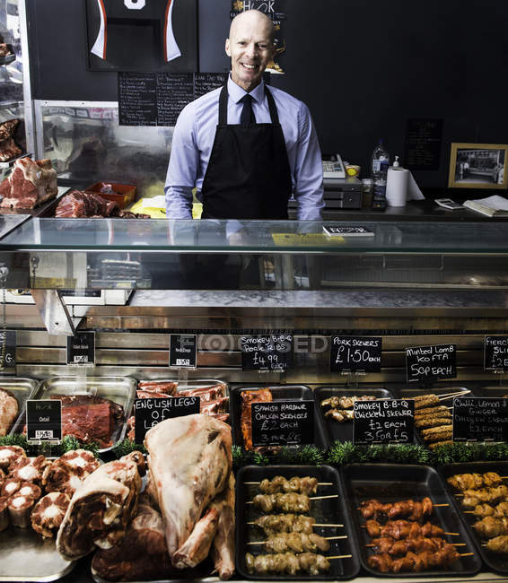 Portrait of butcher, standing behind counter — Stock Photo