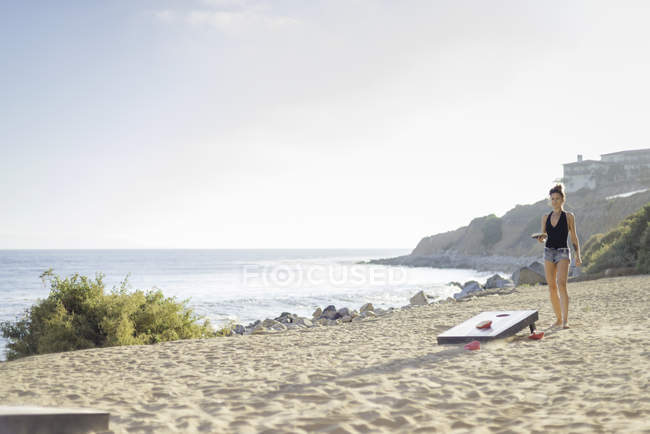 Jovem mulher andando ao longo da praia — Fotografia de Stock