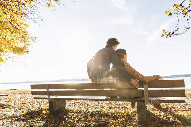 Couple sitting on bench, rear view — Stock Photo