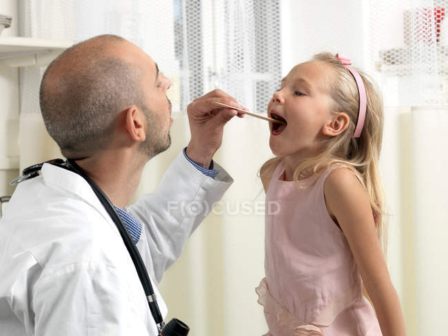 Medico esaminando ragazza in clinica — Foto stock