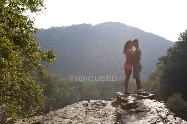 Young couple kissing on rock ledge, Hamburg, Pennsylvania, USA — Stock Photo