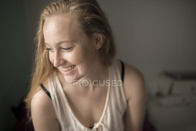 Portrait de jeune femme avec des taches de rousseur riant — Photo de stock